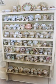 a shelf filled with lots of plates and cups