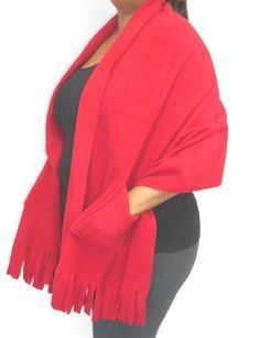 a woman wearing a red shawl and leggings is posing for the camera