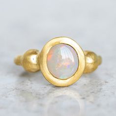 Our ancient inspired Talisman Ring has been set with a semi black opal from Lightning Ridge. Opal measures 9 x 8mm. Band width 2.5mm at back. Metal weight 11g approx. This ring is a size O in 14ct yellow gold with a matte finish. For a high shine finish, please leave a note at checkout. Please note, we can resize 1-2 sizes up or down. Gold Ethiopian Opal Heirloom Rings, Heirloom Ethiopian Opal Gold Rings, Gold Opal Ring With Spiritual Style, Gold Ethiopian Opal Ring Hallmarked, Gold Opal Ring With Birthstone, Gold Opal Birthstone Ring, Yellow Gold Ring With Ethiopian Opal And Birthstone, Yellow Gold Ethiopian Opal Ring With Birthstone, Yellow Gold Ethiopian Opal Birthstone Ring