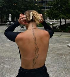 the back of a woman's body with tattoos on her upper and lower back