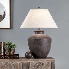 a table lamp sitting on top of a wooden dresser