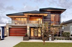 a modern house with two garages on the front and second story, surrounded by grass