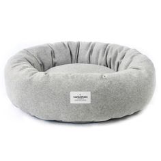 the dog bed is made from grey wool and has a white tag on it's collar