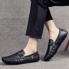 a person sitting on a chair wearing black loafers