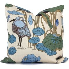 a blue bird sitting on top of a pillow next to water lilies and lily pads