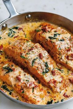 two pieces of meat in a pan with cheese and spinach