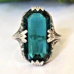 "A lovely vintage navette style green glass sterling ring with a large rectangular glass stone possibly meant to imitate tourmaline or an emerald. The greenish-blue glass stone measuring approximately 18mm x 9mm does show wear commonly seen in vintage glass stones such as surface scratches, edge chips and nicks. The setting has pretty scroll detailing and large decorative prongs, it rises 4.5mm off the finger and the decorative shoulders measure 3mm tapering to 1.4mm. The shank has a slight bend Vintage Promise Ring, Promise Rings Vintage, Alternative Engagement Ring, Greenish Blue, Scroll Design, Design Silver, Ring Vintage, Promise Ring, Sterling Ring