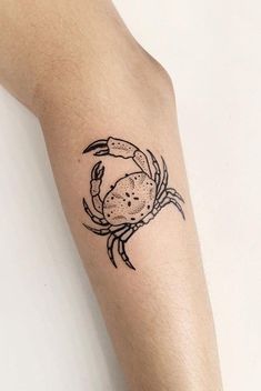 a black and white crab tattoo on the arm