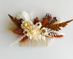 a hair comb decorated with flowers and feathers