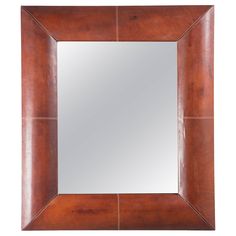 a square mirror with brown leather trimmings on the edges and bottom part of it