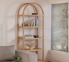 a living room filled with furniture and a book shelf in front of a large window