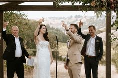 a group of people standing next to each other holding wine glasses in front of them