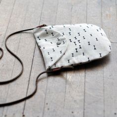 a white and black bag sitting on top of a wooden floor next to a string