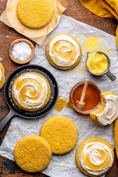 some cookies are sitting on a table with icing and butter in them, along with other desserts