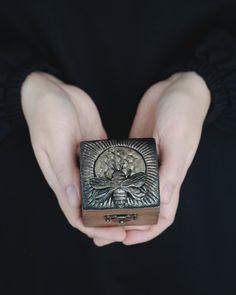 a person holding a small box in their hands