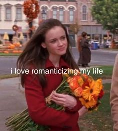 a woman holding flowers in her hands and the words i love romanticizing my life