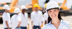 a woman wearing a hard hat in front of construction workers