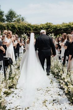 a bride and groom walking down the aisle