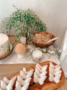 a table topped with lots of food next to a vase filled with flowers and plants