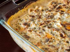 a casserole dish with cheese and other toppings in it on a table