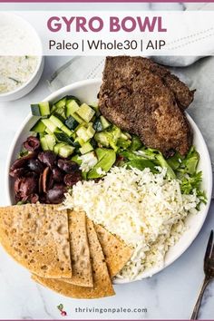 a white plate topped with meat, rice and veggies next to a fork