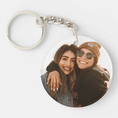 two women hugging each other on a keychain with the photo in front of them