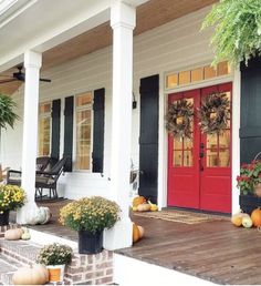 front porch decorated for fall with pumpkins and gourds