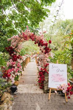 a sign that says save the date on it in front of some flowers and trees