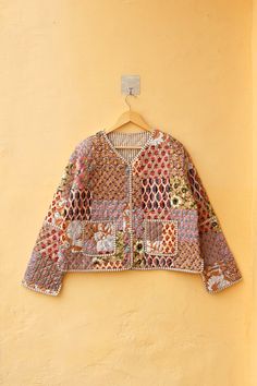 a colorful jacket hanging on a yellow wall