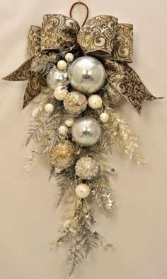 an ornament hanging from the side of a wall decorated with silver and white ornaments