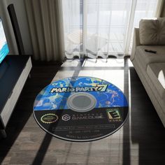 a video game disc sitting on the floor in front of a couch and television screen