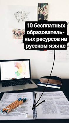 an open laptop computer sitting on top of a desk next to a pile of books