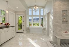 a large white bathroom with marble floors and walls