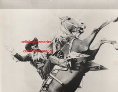 an old black and white photo of a man riding on the back of a horse