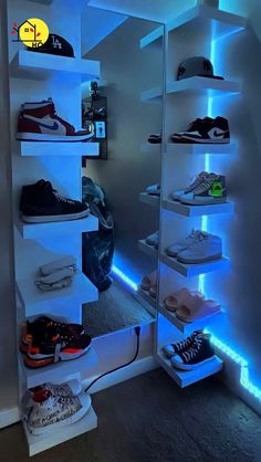 there are many pairs of shoes on the shelves in this room, all lit up with blue lights