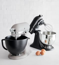 two mixers and eggs on a white counter