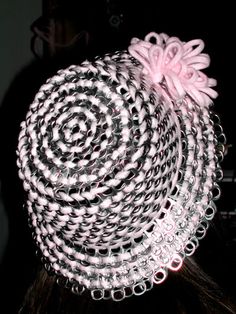 a close up of a person wearing a pink and black hat with circles on it