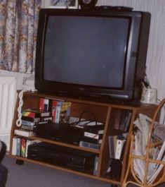 a television sitting on top of a wooden entertainment center next to a radiator