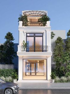 a white two story building with balconies and plants on the balcony