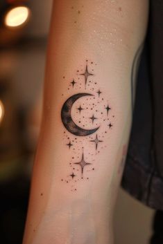 a small crescent and stars tattoo on the arm