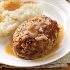 meatloaf with gravy and mashed potatoes on a white dinner plate