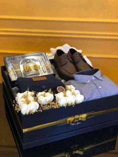 a pair of brown shoes sitting on top of a blue box next to white flowers