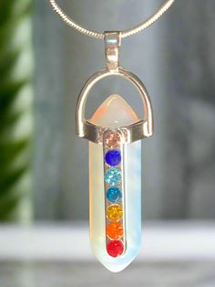 This Chakra Charm Necklace radiates protection with its stunning design and opulent options. Choose from white opal resin or purple sparkle resin, with an 18-inch adjustable black cord necklace. Embrace the power of chakras in style. Enjoy fast shipping or buy in person at our store located in Birchwood Mall, Fort Gratiot MI. We would love to meet you! Adjustable Rainbow Crystal Necklaces As Gifts, Adjustable Rainbow Crystal Necklace Gift, Adjustable Rainbow Crystal Necklaces For Gifts, Spiritual Adjustable Nickel-free Crystal Necklace, Adjustable Spiritual Nickel-free Crystal Necklace, Adjustable Nickel-free Spiritual Crystal Necklace, Nickel-free Adjustable Spiritual Crystal Necklace, Adjustable Nickel Free Crystal Necklace In Spiritual Style, Spiritual Multicolor Jewelry With Adjustable Length