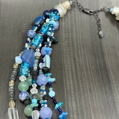 This necklace was designed to emulate ocean waves. I combined many many different beads to create this 6 strand necklace. In this necklace you will find czech glass, labradorite, ceramic beads, lapis, cultured sea glass, seed beads, sodalite, apatite, dragon vein agate, and many more. The ends of the necklace are ancient glass trade beads. The necklace is finished in sterling silver with a lobster clasp and extender chain.This necklace is adjustable from 20” to just under 22”.It weighs 145g. Unique Multi-strand Gemstone Beads, Blue Double Strand Beaded Necklace With Natural Stones, Artisan Multi-strand Blue Necklaces, Blue Multi-strand Natural Stone Necklaces, Blue Multi-strand Natural Stone Necklace, Blue Multi-strand Necklace With Natural Stones, Artisan Blue Double Strand Beaded Necklace, Blue Multi-strand Czech Glass Jewelry, Blue Multi-strand Jewelry With Czech Glass