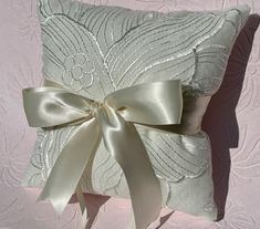 💍This light ivory wedding ring holder pillow is simply elegant.   Made in the USA with FREE and quick SHIPPING. I choose only the most beautiful materials and have years of sewing experience.  🤵The actual pillow is 9" square with double sided matching satin ribbons.  The wide ribbon is also on the back to allow for ease of holding and the 1/4" ribbons hold the rings.   The pillow is made with Irish linen. ️The final 3 pictures show some of my other choices https://jackieoframes.etsy.com/listin Timeless Classic Wedding, Wedding Ring Holder, Classic Wedding Ring, Ring Pillow Wedding, Ring Holder Wedding, 9 Square, Ring Bearer Pillow, Elegant Fabric, Classic Wedding Rings