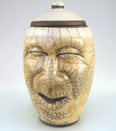 a ceramic face has been made to look like it's being used as a container