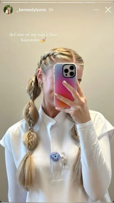 a woman taking a selfie in front of a mirror with her cell phone up to her face