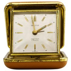 a gold and white clock sitting on top of a table