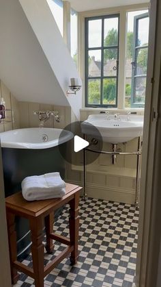 a bathroom with black and white checkered flooring, two sinks and a bathtub