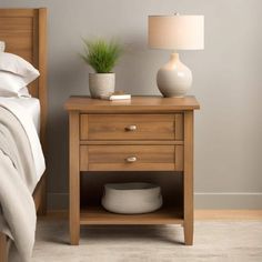 a bedroom with a bed, night stand and lamp on the nightstand next to it